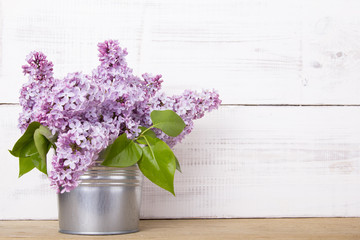 bouquet of lilac flowers on white wooden background