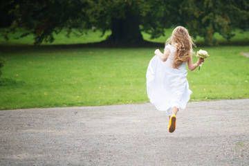 Young girl is runnig away in white dress