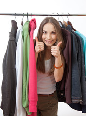 Young woman near rack with hangers