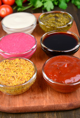 Various sauces on chopping board on table close-up