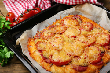 Homemade pizza on baking paper close up