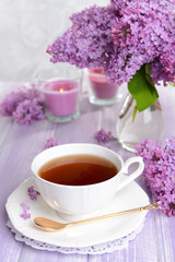 Beautiful lilac flowers with cup of tea