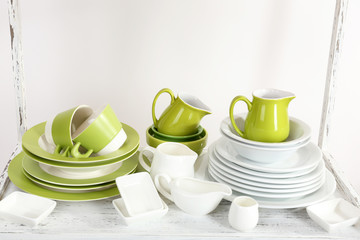 Different tableware on shelf, isolated on white
