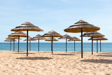 Blue sky, blue sea and parasols at  beach in Portugal - 64969150