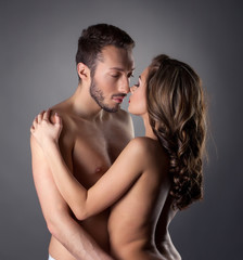 Passionate nude lovers embracing in studio