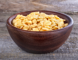 cornflakes in a wooden bowl on a rustic table