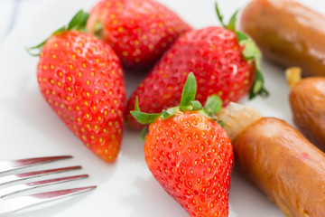 fresh strawberry with smoked sausage on the white plate