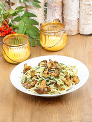 Macaroni with mushrooms. Plate standing on wooden table