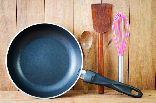 Closeup of  iron frying pan and wooden utensils
