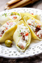 Italian cuisine: stuffed pasta shells, tomatoes and pesto sauce