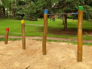 Fototapeta premium Steel horizontal bars on wooden pillars in children playground. 