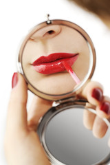 Naklejka premium beautiful red lips in a hand mirror