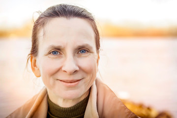 A warm portrait of a nice senior woman close to the river