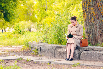 Elegant businesswoman sitting and reading an adventure book