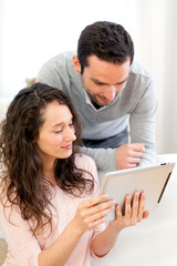 Happy young couple surfing on a tablet