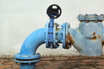 blue  rusty metal industrial water pipes with a valve.