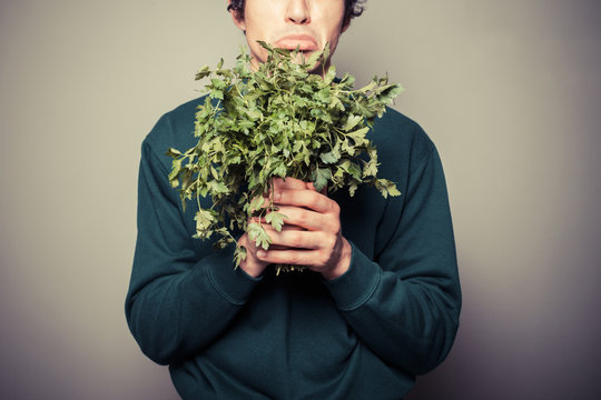 Sad man holding a bunch of parsley