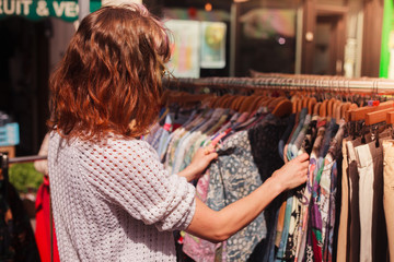Woman browsing clothes at market - 64981912