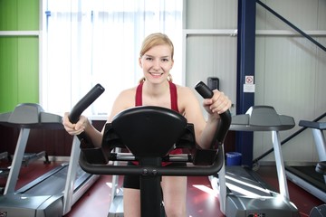 Frau im Fitnessstudio trainiert auf Fahrrad