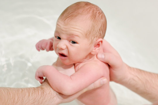 Man give a bath his newborn baby