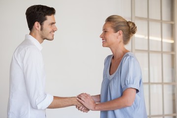Obraz premium Casual business woman shaking hands with man