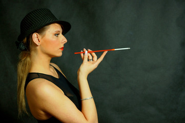 Fototapeta Piekna kobieta z papierosem i w kapeluszu z profilu obraz