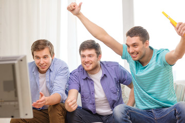 Fototapeta premium happy male friends with vuvuzela watching sports