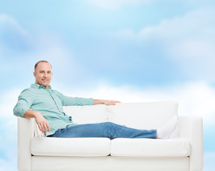smiling man lying on sofa