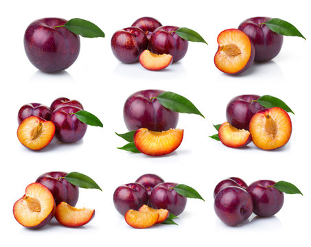 Set ripe plum fruits with green leaves isolated on white