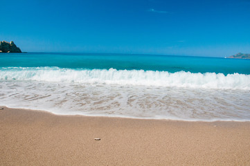 Beautiful surf on the beach. Mountains on the horizon.