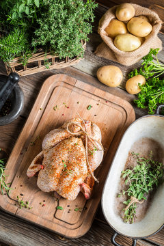 Preparing roast chicken with herbs and vegetables