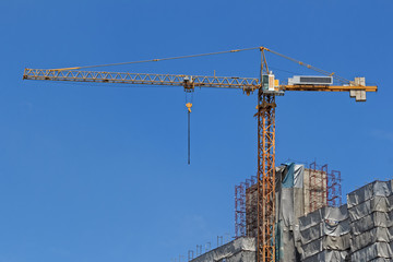 Yellow Construction Crane against Blue Sky Background