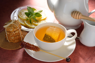 Cup of tea with tea bag and cookies on table
