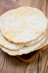 Mexican corn tortillas over wooden background, vertical shot
