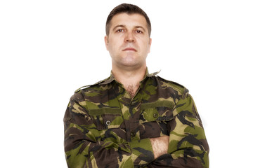 portrait of a serious soldier standing against a white backgroun