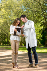 Fototapeta premium Young doctor with woman assistant in the park