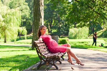 young pregnant woman in park