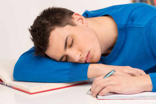 young attractive man sleeping on table.