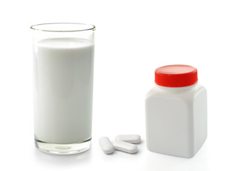 pill bottle and glass of milk isolated on white background