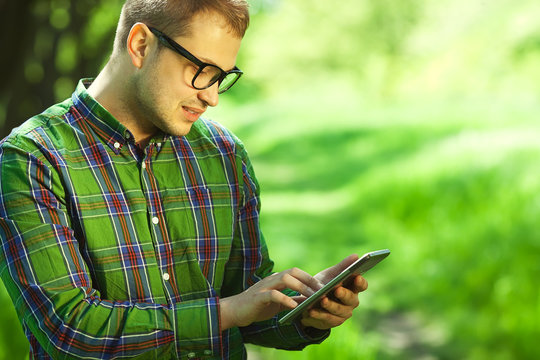 Gadget Freak Concept. Hipster Reading E-book In Park