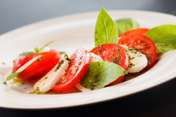 Tomato and mozzarella with basil leaves