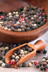 Peppercorns with a wooden spoon on a rustic table