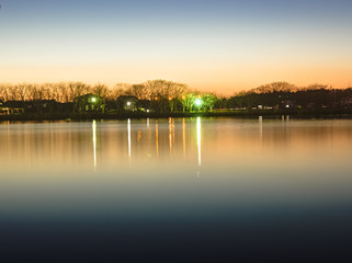 Naklejka na ściany i meble Reflection of sunset glow on the park pond, HDR
