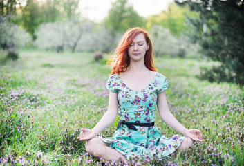 Pretty woman meditate in the park