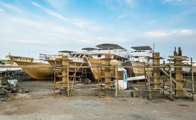 Old boats are being repaired on the shore at the port