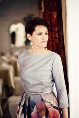 Pretty short-haired woman posing in trendy dress