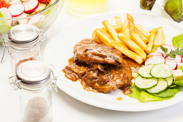 Pork chop with sauce, mushrooms and chips