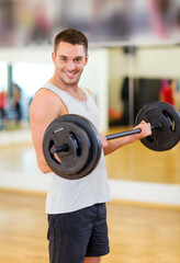 smiling man with barbell in gym