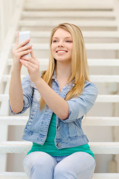smiling female student with smartphone
