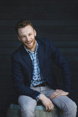 Man in a jacket sitting on a barrel